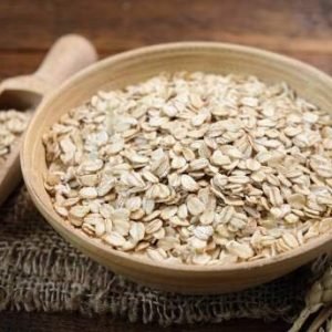 Rolled oats in a wooden bowl. Healthy whole grain oats